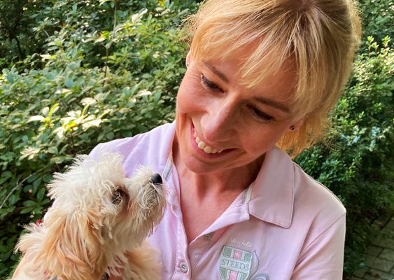 Frau Rychlik hat einen Hund im Arm